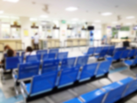 abstract blurred image of patient waiting on blue seat for pay money and receive medicine at cashier pharmacy counter at hospitalの写真素材