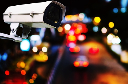 CCTV, security camera system operating record and property protection with blurred image of street traffic light in the city at night, vintage color tone, surveillance security technology conceptの写真素材