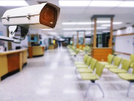 CCTV, security indoor camera system operating with blurred view of empty chairs in lobby for waiting at clinic or hospital, surveillance security technology conceptの写真素材