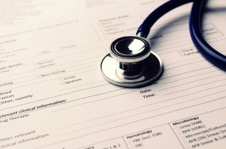 stethoscope and patient information form on desk, healthcare technology, medical report record and history patient concept, selective focus, vintage color toneの写真素材