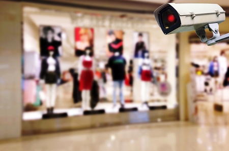 CCTV, security indoor camera system operating with blurred image of showcases fashion clothes display in department store shopping mall, surveillance security and safety technology conceptの写真素材