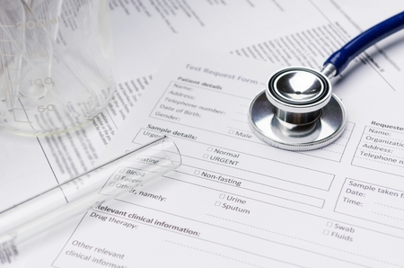 close up stethoscope, test tube, beaker and patient information form on desk, heart healthcare technology, medical diagnosis, medical report record and history patient concept, selective focusの写真素材
