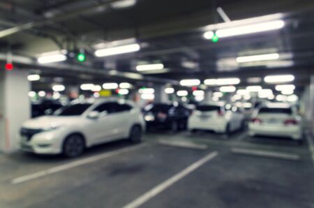 abstract blurred image of under ground indoor car parking garage area, RFID solution management system, car park system technology concept, vintage filter color tone effectの写真素材