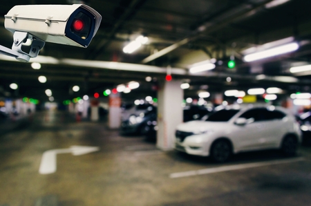CCTV, security indoor camera system operating with blurred image of under ground indoor car parking garage area, RFID solution management system, surveillance security and safety technology conceptの写真素材