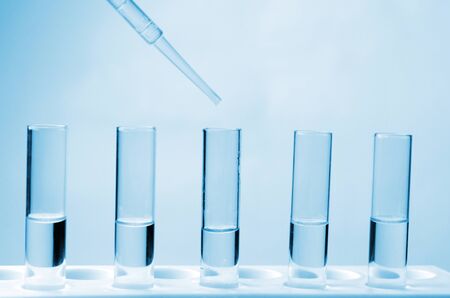 science dropping chemical liquid to test tube in laboratory, science, chemical and medical research concept, blue color tone, soft and selective focusの写真素材