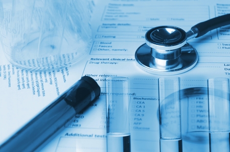 double exposure of stethoscope, test tube, beaker and medical information form on desk, medical research diagnosis, blood test, medical report record and history patient concept, blue color toneの写真素材