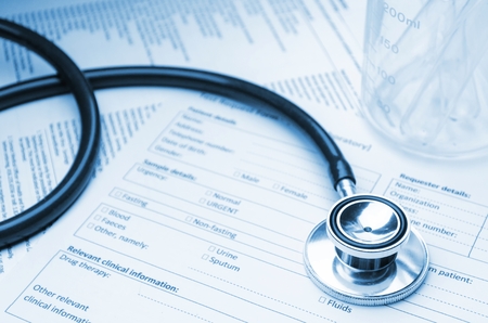 stethoscope, test tube, beaker and medical information form on desk, healthcare, medical research diagnosis, medical report record and history patient concept, selective focus, blue color toneの写真素材