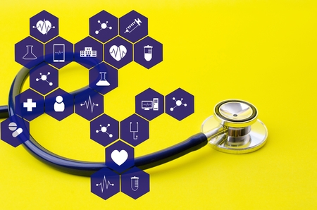 stethoscope on yellow background with medical icon in hexagon pattern, heart health care, laboratory, science, chemical and medical research conceptの写真素材