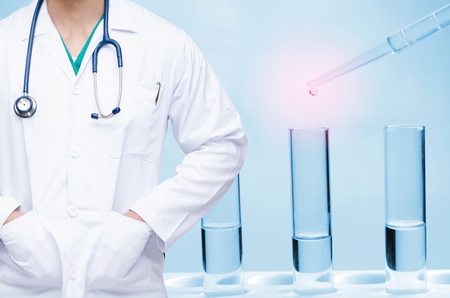 smart doctor with a stethoscope and dropping chemical liquid to test tube background, people, laboratory, science, chemical and medical research conceptの写真素材