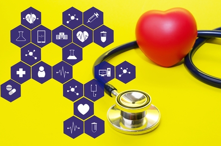 stethoscope and red heart on yellow background with medical icon in hexagon pattern, heart health care, laboratory, science, chemical and medical research conceptの写真素材