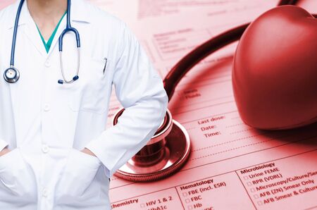 smart doctor with a stethoscope and stethoscope, red heart and medical information form on desk background people, laboratory, science, chemical and medical research conceptの写真素材