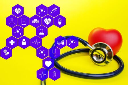 stethoscope and red heart on yellow background with medical icon in hexagon pattern, heart health care, laboratory, science, chemical and medical research conceptの写真素材