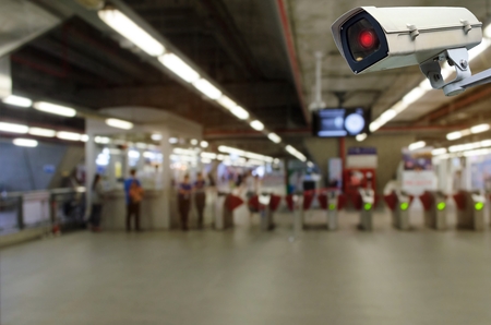 CCTV security indoor camera system operating with blurred image of entrance of subway or railway at train station, transportation, surveillance security and safety technology conceptの写真素材