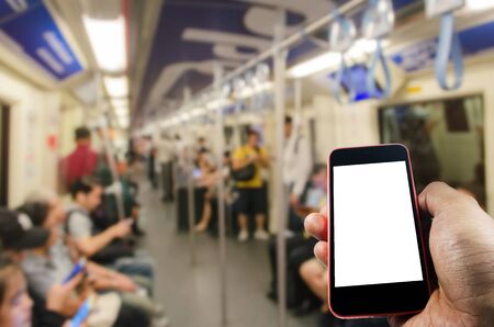hand holding white blank screen mobile phone in subway with many people, people, transportation, technology, internet, network connection and social media conceptの写真素材