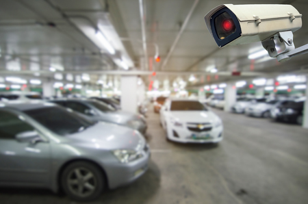 CCTV security indoor camera system operating with blurred image of under ground indoor car parking garage area, RFID solution management system, surveillance security and safety technology conceptの写真素材