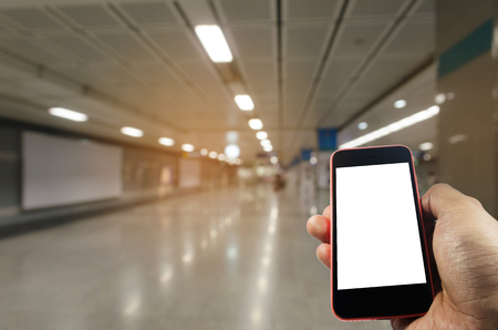 hand using mobile phone with blank screen over blurred view of subway train station, internet, social media technology and network connection conceptの写真素材