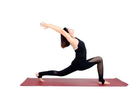 middle aged asian woman doing yoga in Virabhadrasana One or Warrior One yoga pose on the mat isolated on white background, exercise fitness, sport training, healthy lifestyle and people conceptの写真素材