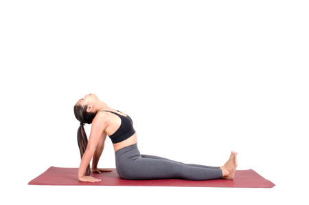 young asian woman doing yoga in Purvottanasana or Upward Plank yoga pose on the mat isolated on white background, exercise fitness, sport training, healthy lifestyle conceptの写真素材