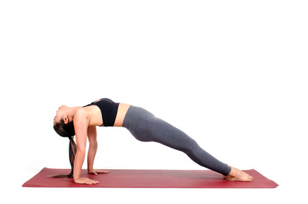 young asian woman doing yoga in Purvottanasana or Upward Plank yoga pose on the mat isolated on white background, exercise fitness, sport training, healthy lifestyle conceptの写真素材