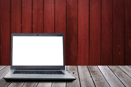 laptop computer with blank screen for presentation on wooden desk and old wooden wall background, advertising, commercial, marketing, technology, internet and business conceptの写真素材