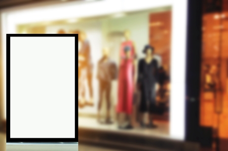 vertical advertising billboard or blank showcase light box for your text message or media content in front of fashion clothing store showcases, sale, commercial, marketing and advertisement conceptの写真素材