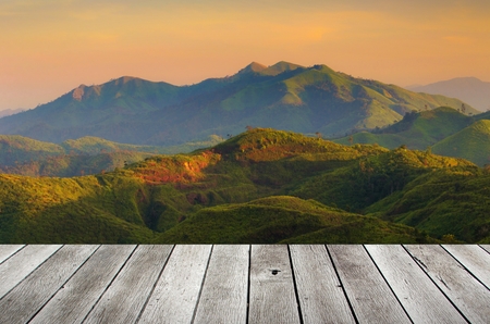 wooden terrace or desk with copy space for display of product or object presentation with beautiful sunset in the mountains, landscape nature backgroundの写真素材