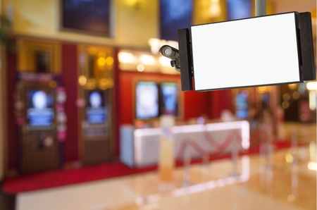 CCTV and LCD TV with white blank screen or billboard for your text message or media content with blurred image of ticket sales counter at movie theater, advertising, commercial and marketing conceptの写真素材