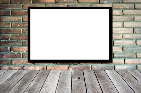 blank advertising billboard or wide screen television on old vintage brick wall background and wooden shelf or desk, copy space for display of product presentation, commercial and marketing conceptの写真素材