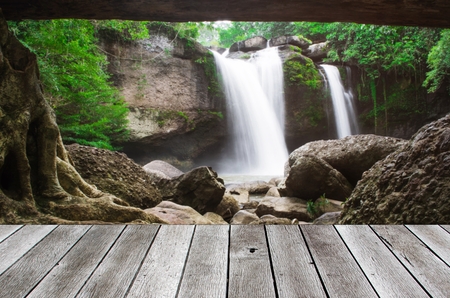 wooden floor terrace or plank desk with beautiful nature waterfalls in deep forest background, copy space for display of product or object presentationの写真素材
