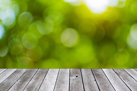 wooden floor terrace or plank desk with green nature bokeh light background, copy space for display of product presentation, commercial and marketing conceptの写真素材