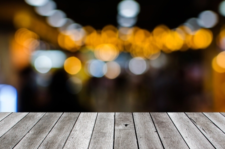 wooden floor terrace or plank desk with bokeh light in dark background, copy space for display of product presentation, commercial and marketing conceptの写真素材