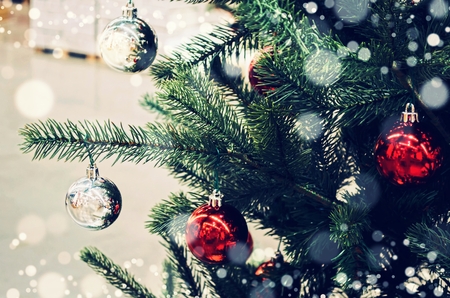 close up decoration ball hanging on christmas tree with snow effect, happy new year and merry christmas festival concept, vintage color tone effectの写真素材