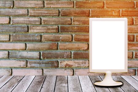 blank menu restaurant plastic holder on wooden desk with old vintage brick wall background, advertisement, commercial and marketing concept, copy space for text or media contentの写真素材