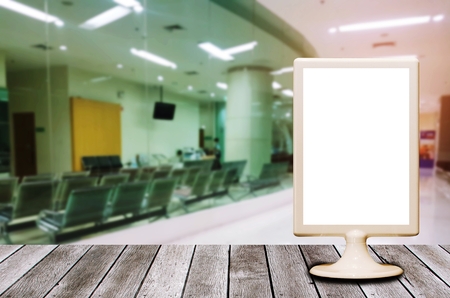 mini blank advertising billboard on desk with waiting chair in hospital, copy space for text or media content, advertisement, commercial and marketing conceptの写真素材