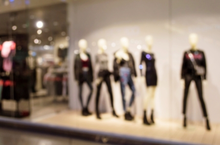 blurred image of woman fashion clothes shop showcase in department store shopping mall for backgroundの写真素材