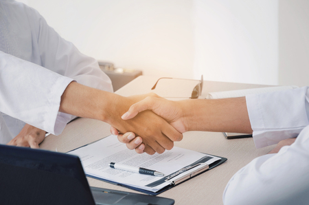 business people handshake and clapping hand after finishing up a business meeting in office, successful, meeting, partnership, teamwork, community, connection concept, vintage tone, selective focusの写真素材