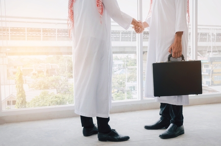 Arabian business man transfer deal after finishing up a business meeting in office, handover of a...