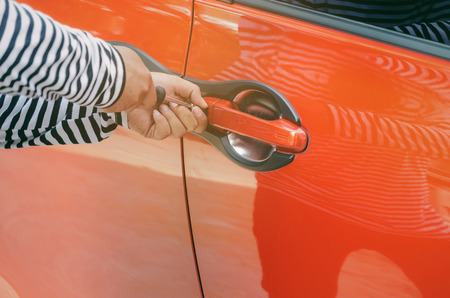 close up of hand thief in black and white jacket using screwdriver to open car door to stealing a car, break into the car, crime, robber and steal conceptの写真素材