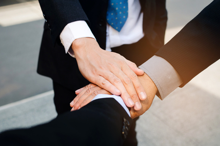 close up group of three business man team joining hands together in the modern city, team leader, successful, support, meeting, partner, teamwork, community and connection concept, selective focusの写真素材