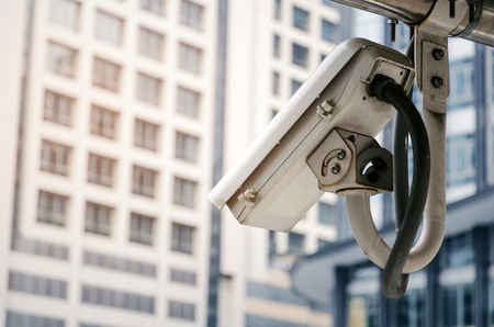 CCTV, security camera system operating in modern city building background, surveillance security,...