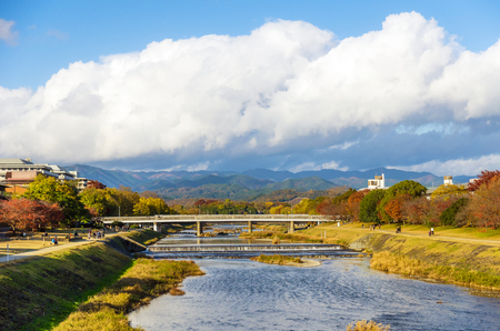 beautiful view of people, mountain, bridge, lake colorful trees and blue sky in autumn season from Kyoto, Japan, travel landscape and nature conceptの写真素材