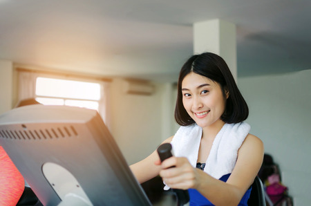 young happy smile asian woman slim body looking into camera and exercisingの写真素材