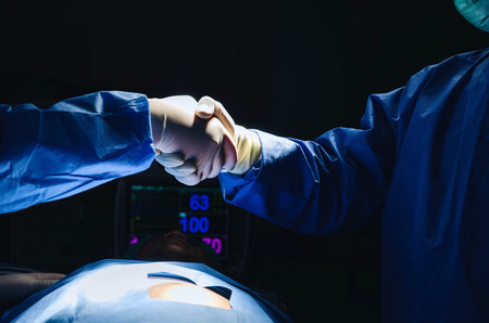 Doctor shaking hands with Assistant after surgeons work for rescue patient in operation room at hospital, emergency case, surgery, medical technology, health care cancer and disease treatment conceptの写真素材