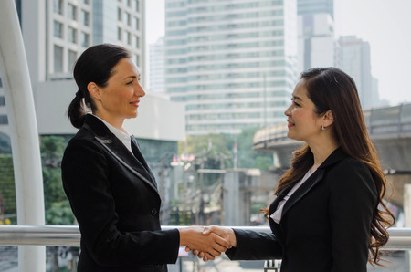 Nice to meet you. Deal. two business woman handshake after finishing up a business meeting in the modern city, congratulation, success, meeting, partner, teamwork, community and connection conceptの写真素材
