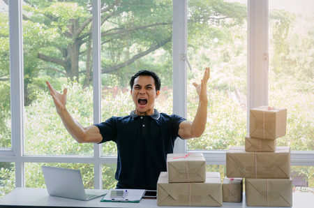 Start up. young man happy after new order from customer with laptop computer, mobile phone, delivery...