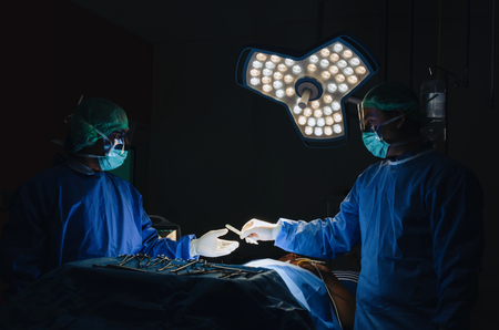group of surgeons team sending surgical instrument to hand work for rescue patient in operation room at hospital, emergency case, surgery, medical technology, health care cancer, disease conceptの写真素材