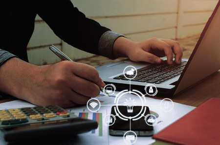 young accountant or business man working and writing with report sheet, calculator, laptop,...