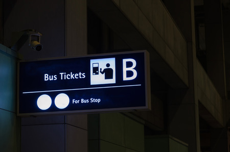 bus tickets sign billboard at airport or train station at night, transportation and travel conceptの写真素材