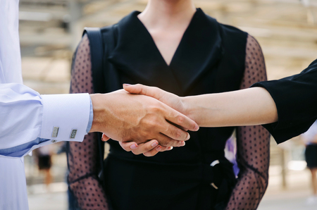 midsection group of young Arabian man handshake with business woman after finishing up meeting in modern city background, partnership, teamwork, community, connection financial and investment conceptの写真素材