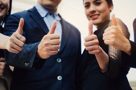 close up of hand group of young business people team in suit showing thumbs up as like sign together in the city, successful, support, meeting, partner, teamwork, community and connection conceptの写真素材